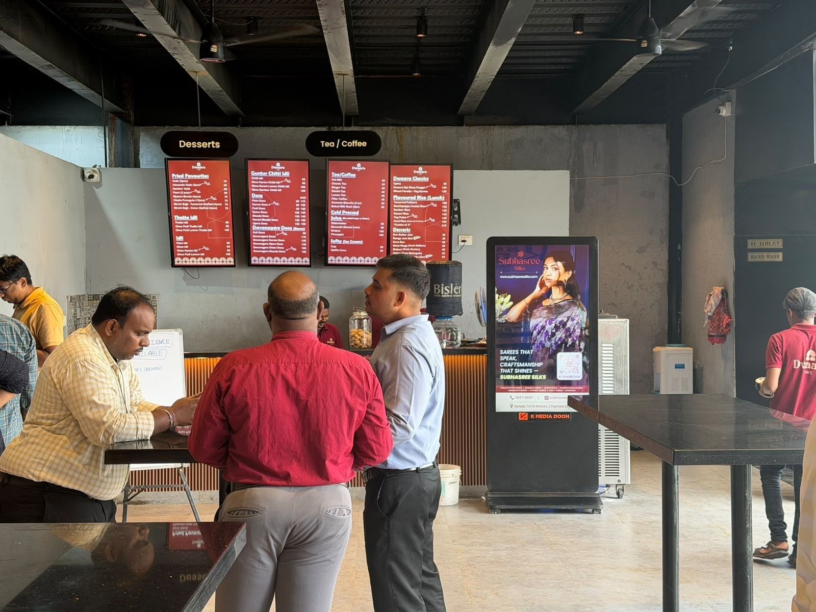 KMEDIA screen at Dwaara restaurant dessert counter