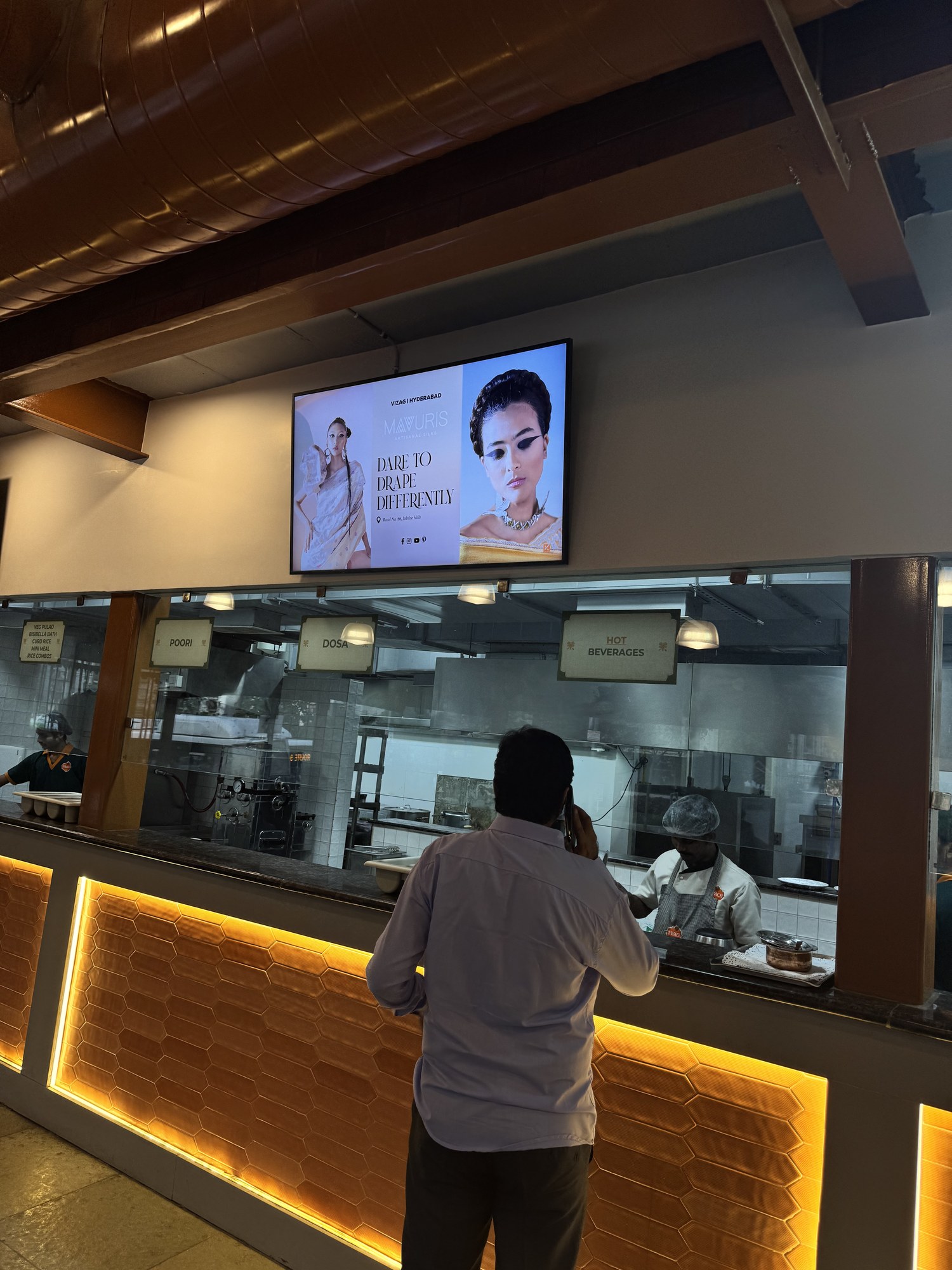 Mavuris artisanal silks campaign on KMEDIA screen above a food counter