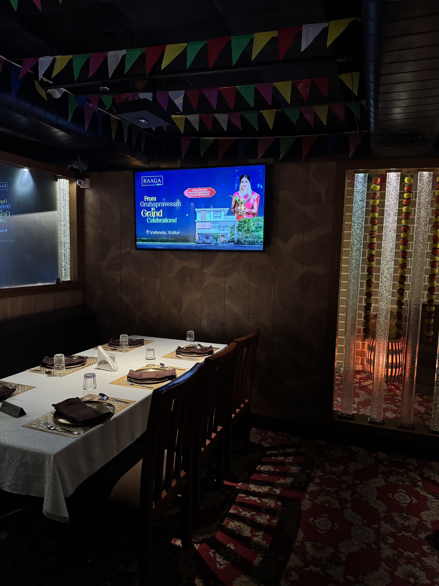 Raaga real estate ad on KMEDIA screen in a private dining room